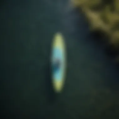 Aerial view of paddle boarder exploring a serene lake