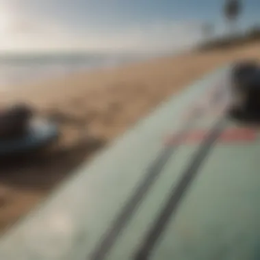 A close-up of a surfboard with essential gear laid out, highlighting the equipment for beginners.