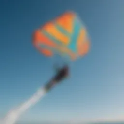 Kiteboarder soaring through the air with vibrant kite colors against a clear blue sky