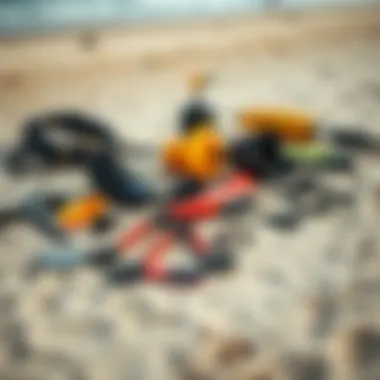 Diverse watersports gear laid out on a sandy beach.
