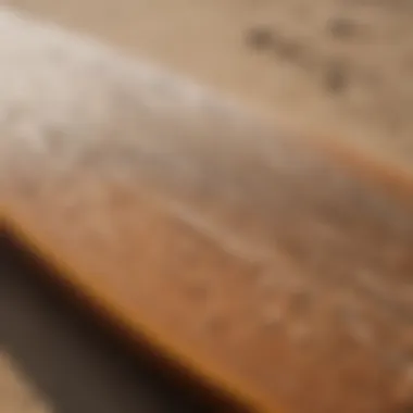 Surfboard with intricate design laid on sandy beach