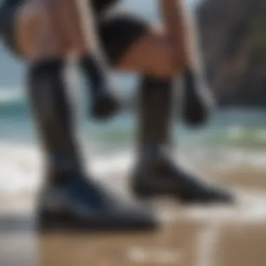 A surfer putting on snug-fitting neoprene booties