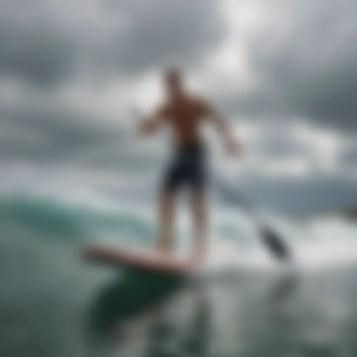 Stand-up paddle surfer catching a wave under cloudy skies