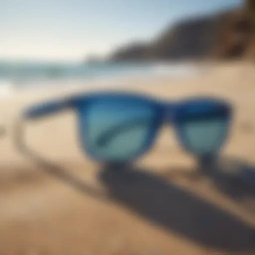 Stylish surf sunglasses with blue lenses on sandy beach