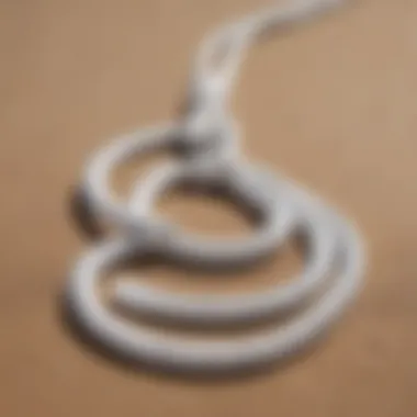 Close-up of white surf leash coiled neatly on the sand